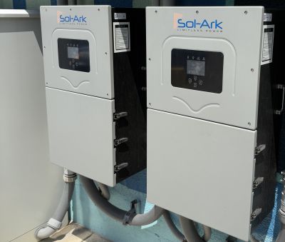Two Sol-Ark 15K-2P-N Hybrid Inverter are operating in Parallel mounted on a wall.